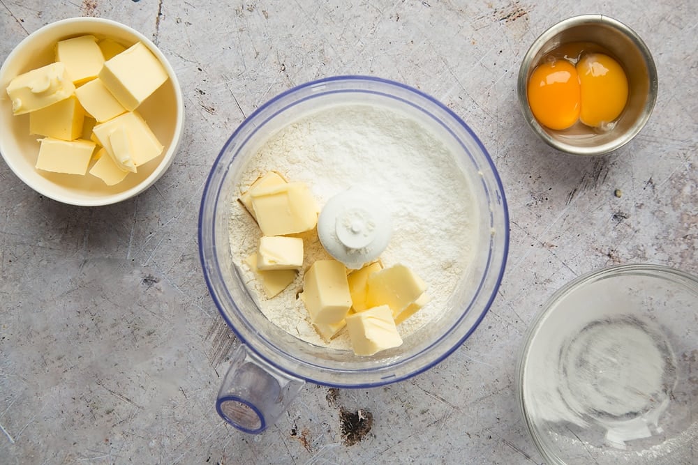 flour and half the butter in a blender bowl along with 2 other bowls with eggs and butter inside.