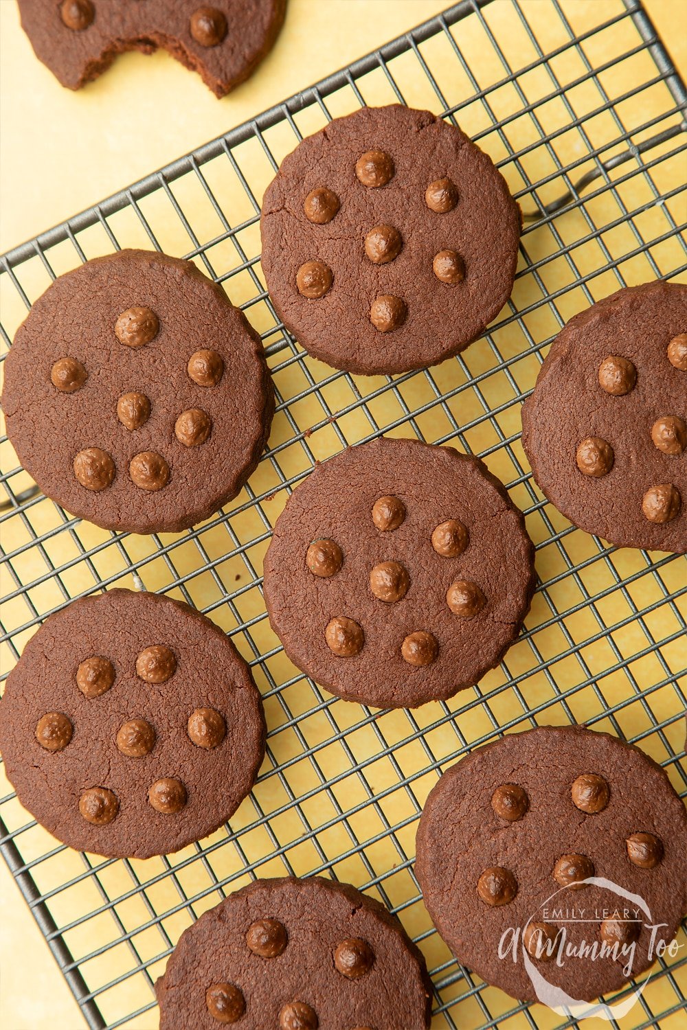 Chocolate shortbread cookies, studded with chocolate drops, cooling on a wire rack.