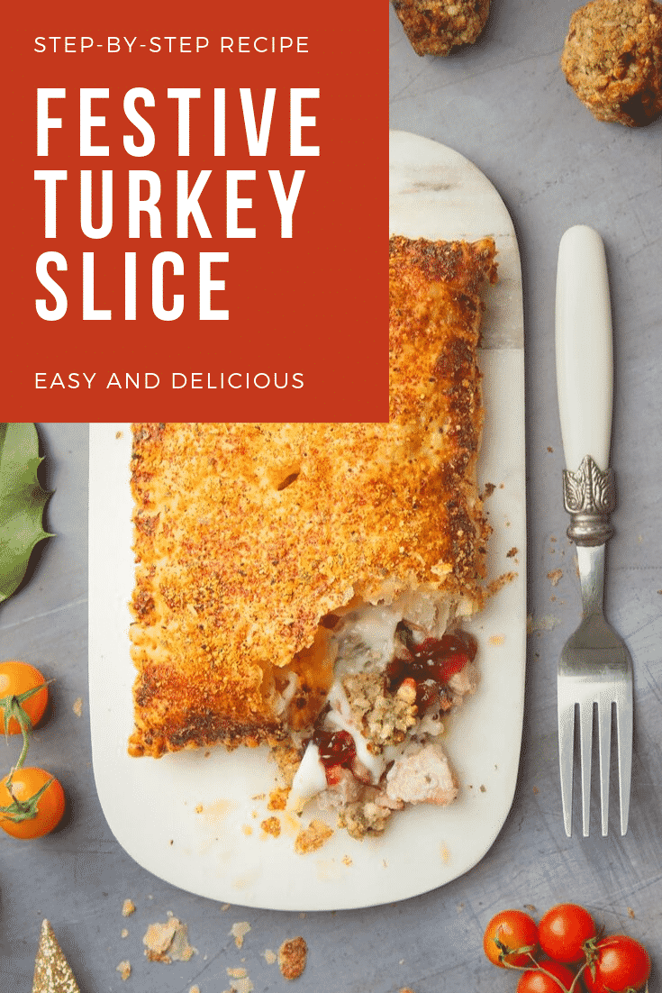 Close up of a cut open turkey slice on a white plate with a decorative fork at the side.