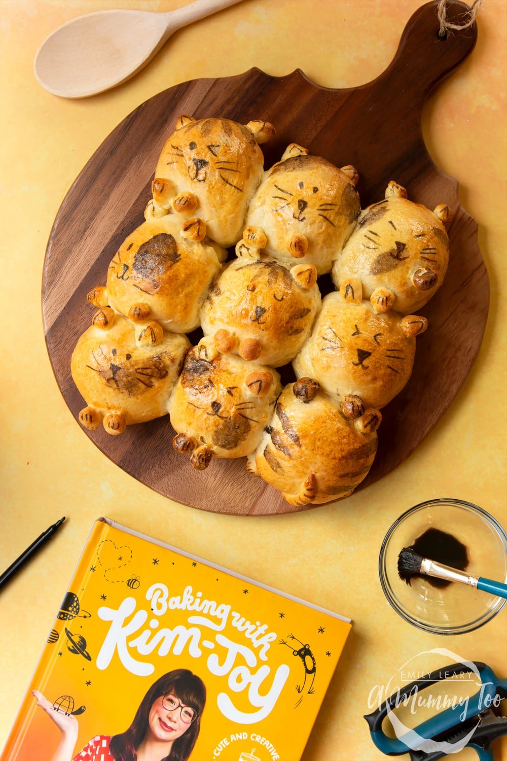 Kim-Joy's Tangzhong Cat Buns - nine bread rolls on a board, shaped and decorated to resemble cats.