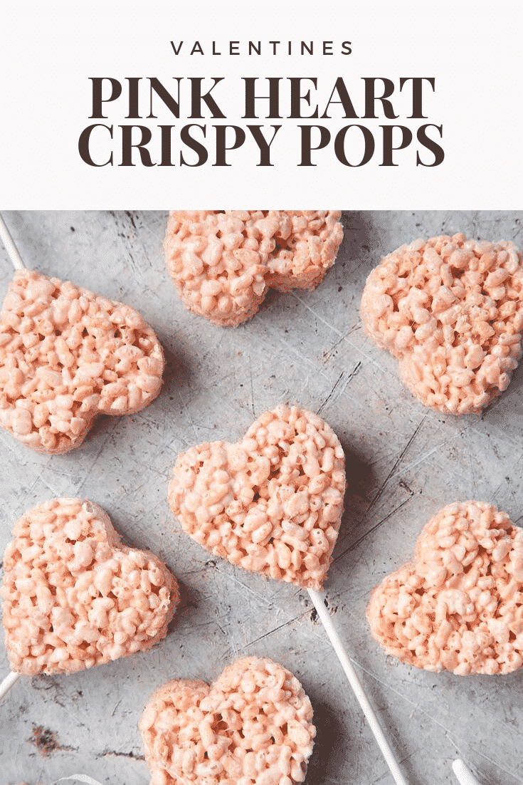 Close up of heart crispy cake pops on a grey background. At the top of the image there's some text explaining the image for Pinterest.