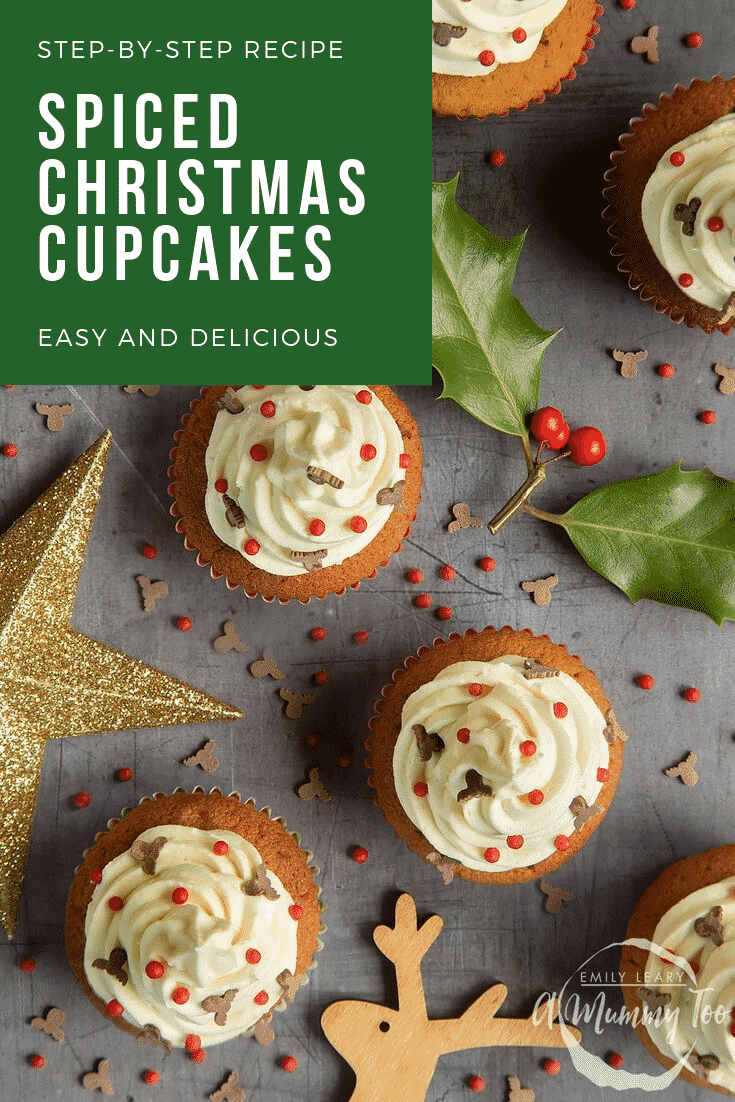 Overhead shot of the finished spiced Christmas cupcakes with marzipan frosting on a grey table. In the top left hand corner there's some white text on a green background describing the image for Pinterest. 