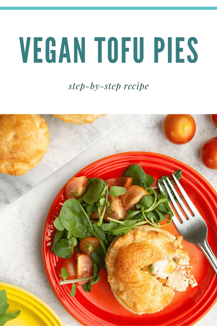 Overhead shot of a cut open vegan tofu pie on a red plate with a side salad. There's a fork sitting on the side alongside osme of the additional pies and cherry tomatoes. At the top of the image there's some teal text describing the image for Pinterest.