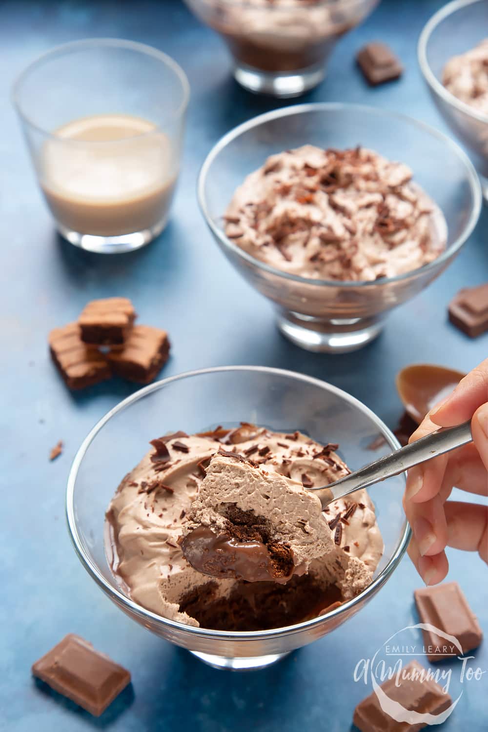 A  bowl of baileys triple chocolate trifle with a spoon dipped inside.