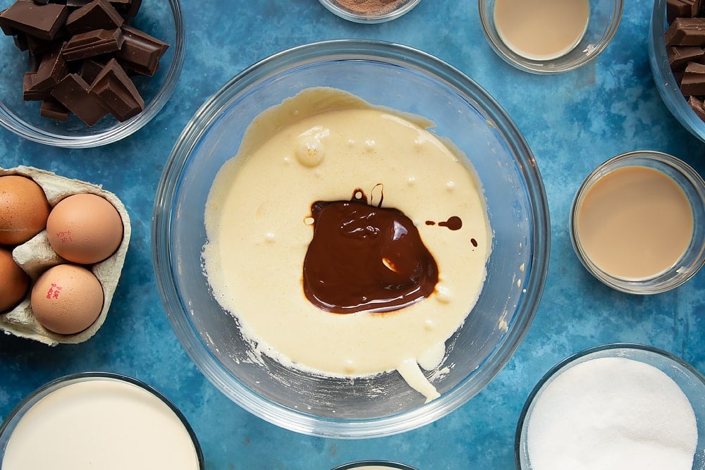 Melted chocolate being added to the bowl of mixed eggs and sugar ready for the baileys triple chocolate trifle