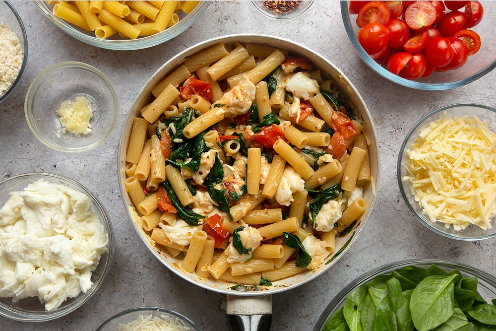 The cooked ingredients for Cherry tomato, spinach and garlic mozzarella pasta bake mixed together. 