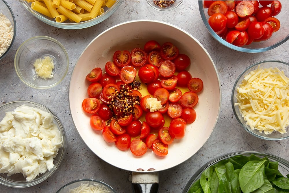 Some of the ingredients for the Cherry tomato, spinach and garlic mozzarella pasta bake being added to the pan. 