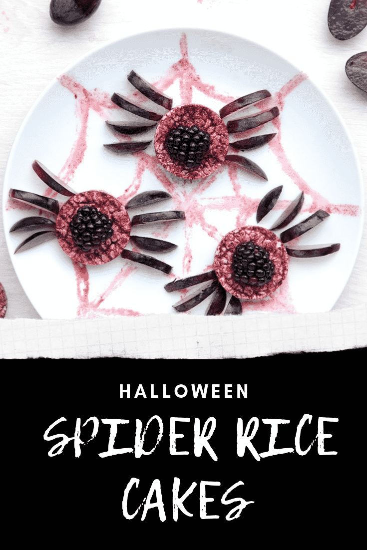 Halloween rice cakes, decorated with blackberries & grapes to look like spiders on a spider's web. Caption in white text on black reads: Halloween spider rice cakes.