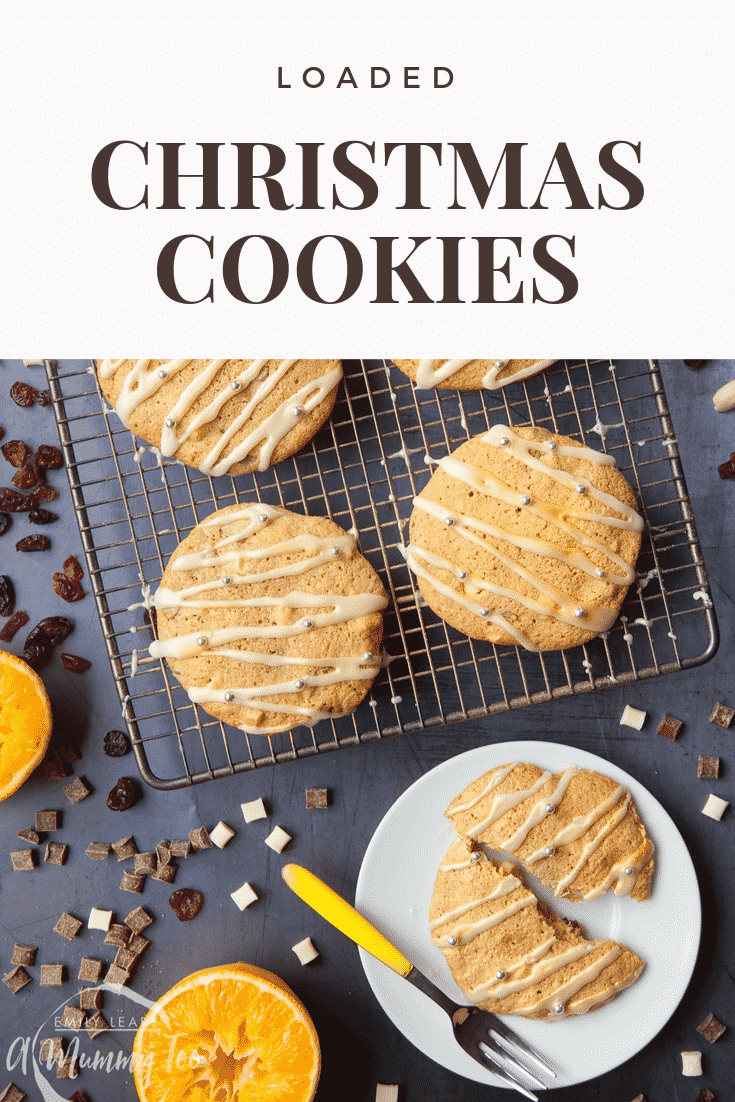 Four loaded Christmas cookies on a baking rack and one loaded Christmas cookie on a plain white plate with a fork on the side.