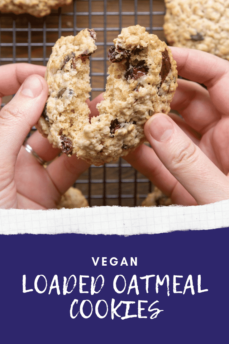 A hand holds a vegan oat cookie and is breaking it open. Caption reads: vegan loaded oatmeal cookies