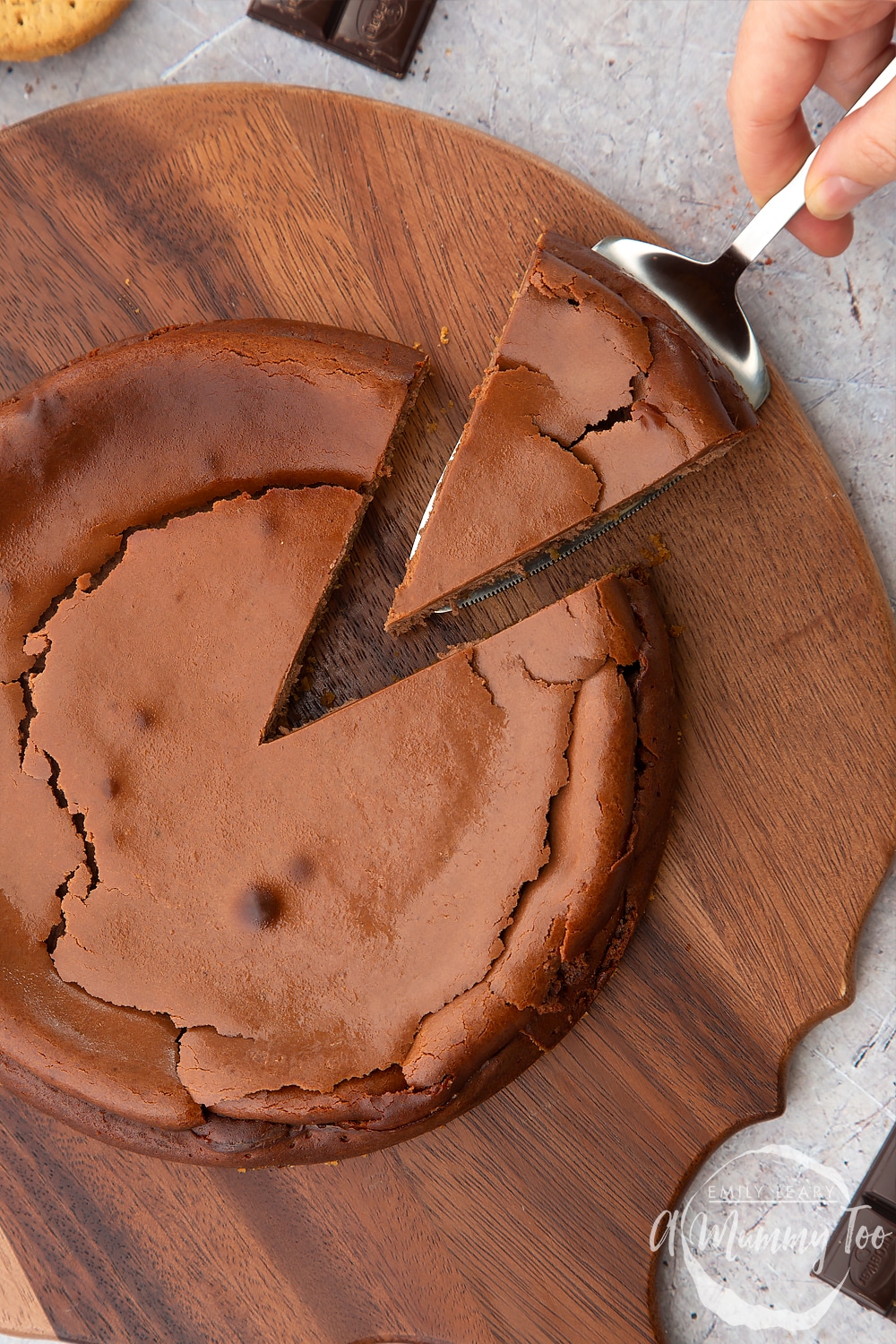 Overhead shot of the baked chocolate cheesecake with one slice being pulled away on a cake slice. 