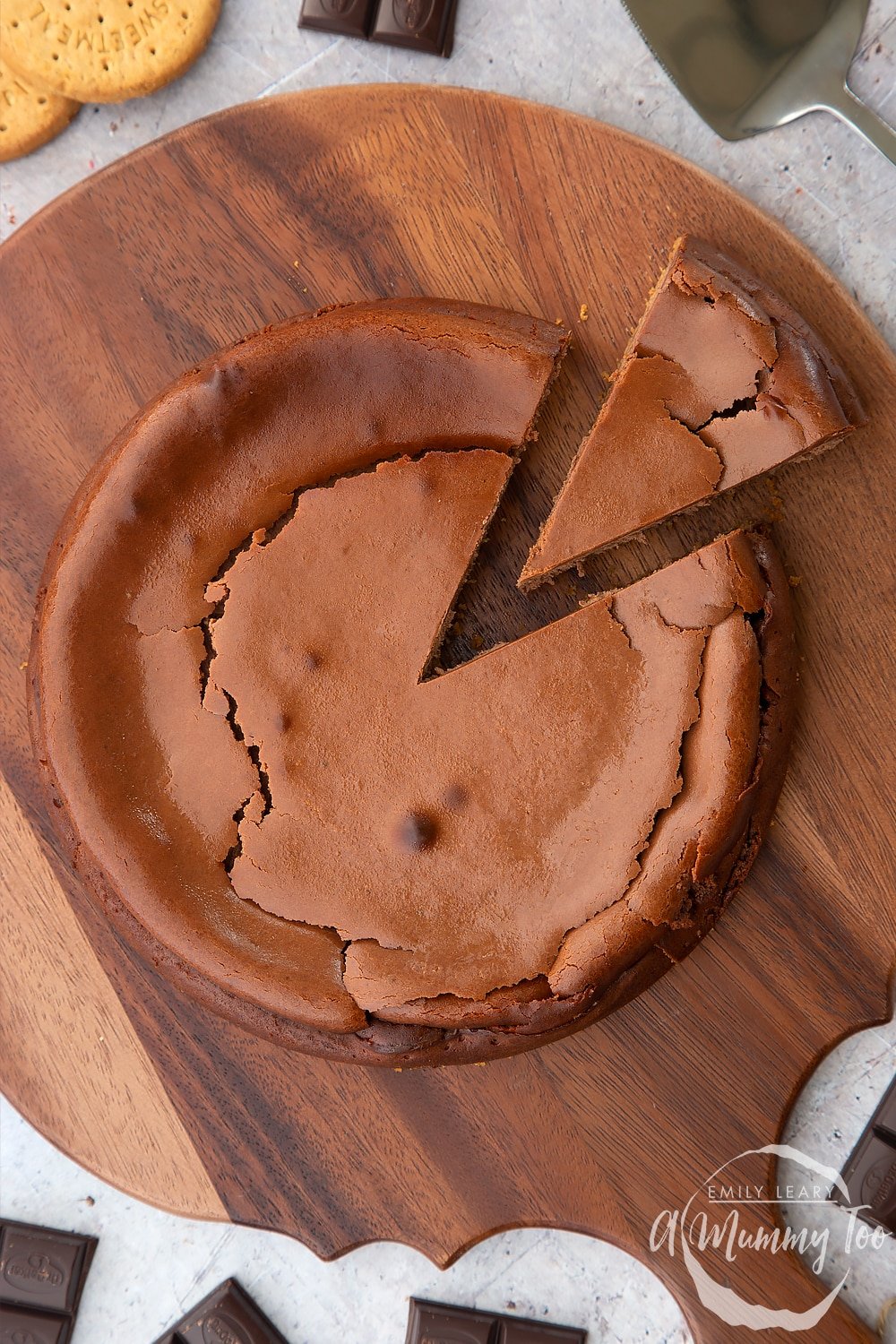 Overhead shot of a baked chocolate cheesecake with a slice cut out. 