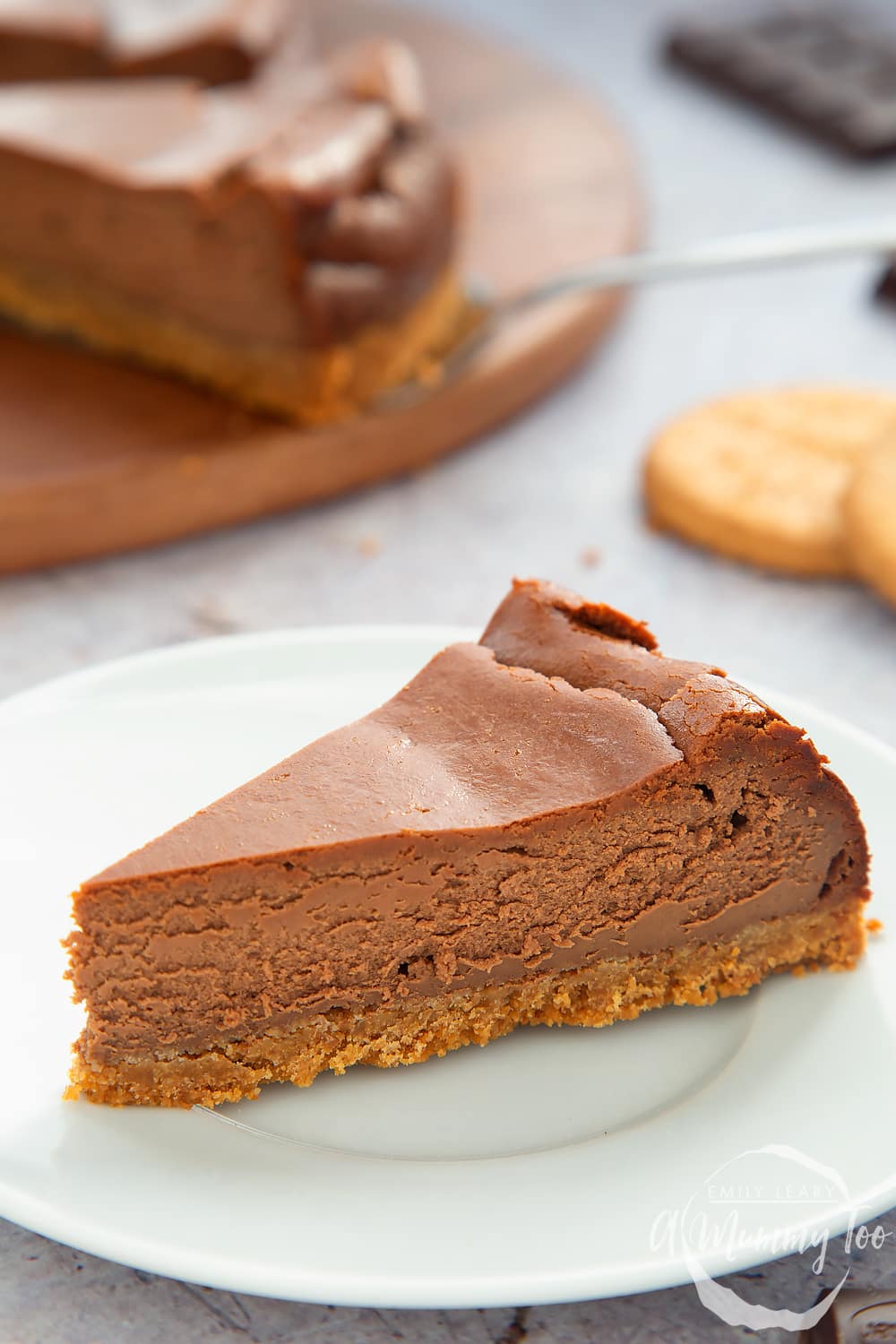 Close up of the side of the baked chocolate cheesecake on a white plate. 