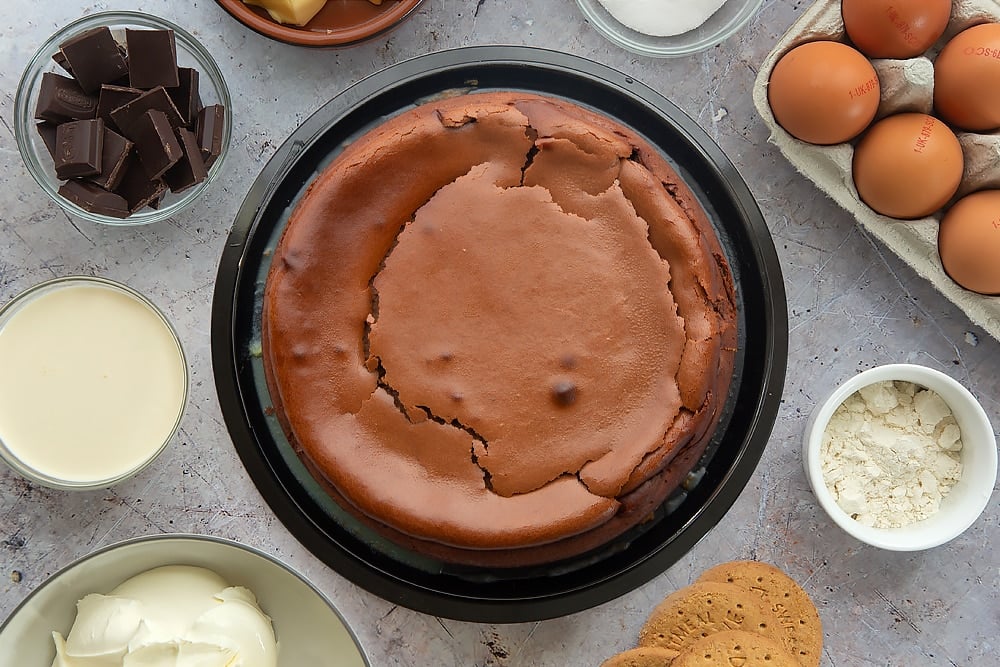 Overhead shot of the finished baked chocolate cheesecake surrounded by some of the ingredients which have been used in the recipe.