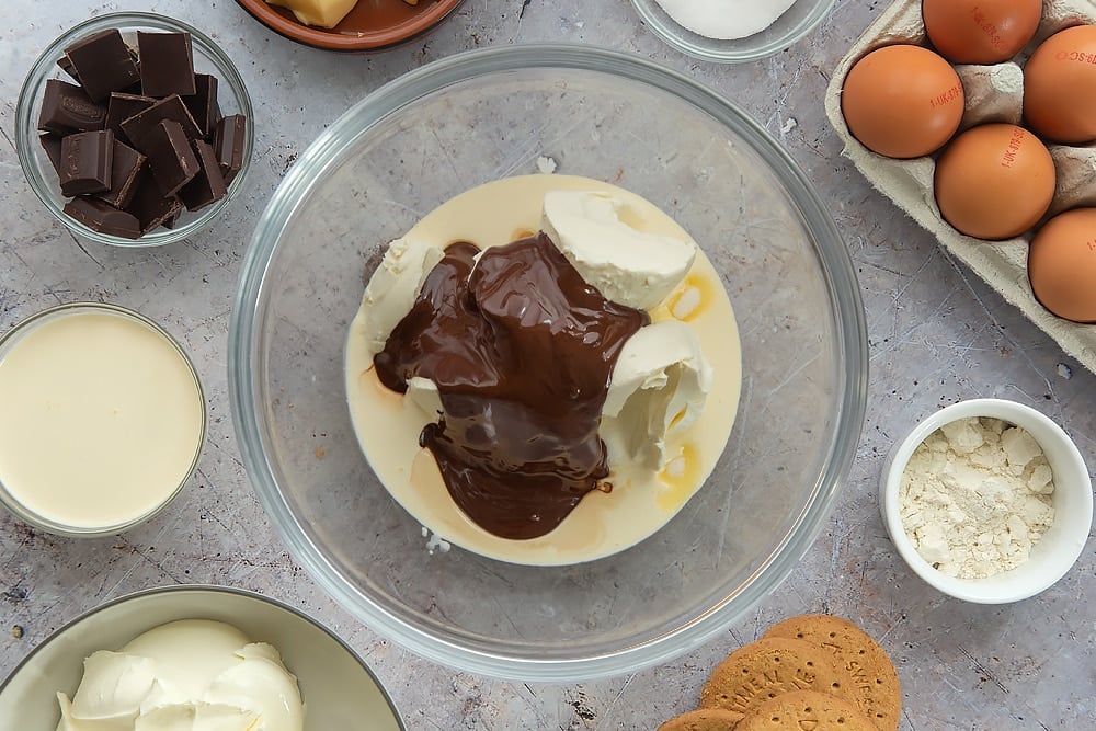 Adding the chocolate into the mixture for the baked chocolate cheesecake. 