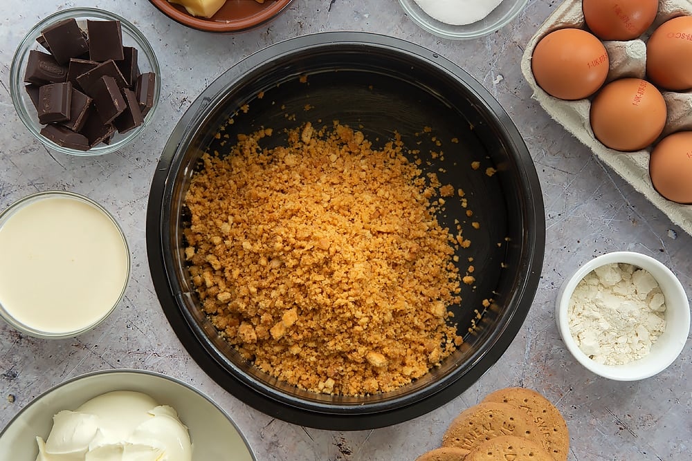 Overhead shot of the bottom base of the baked chocolate cheesecake being poured into a tin. 