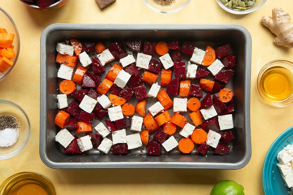 Adding feta to the pan of ingredients required to make the Beetroot and feta salad with couscous. 