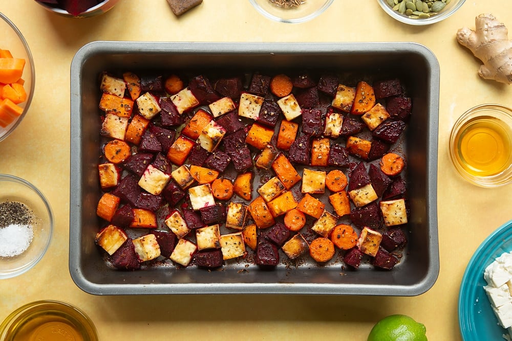 Overhead shot of the baked ingredients inside a pan required for the Beetroot and feta salad with couscous.