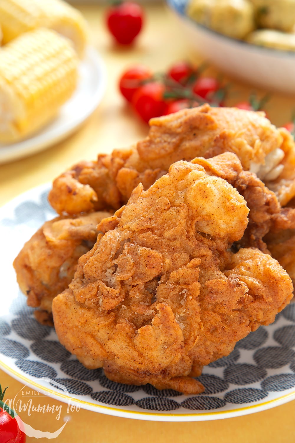 Gordon Ramsay’s buttermilk fried chicken arranged on a plate. A large chicken thigh is in the foreground, perfectly coated and fried. 