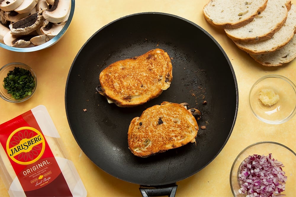 A pan containing to cook toasties, the bread is golden brown