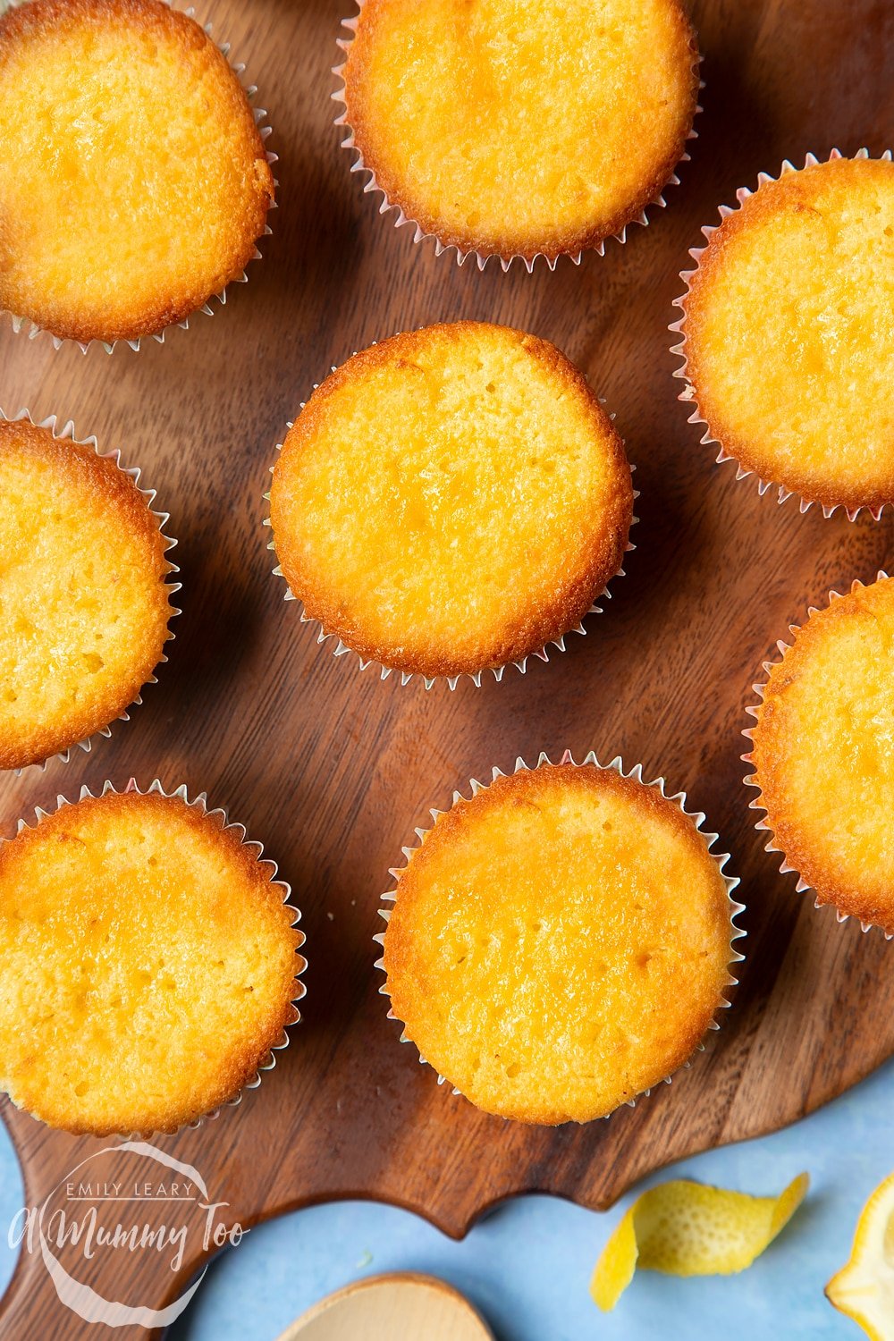 Lemon drizzle cupcakes on a wooden board.