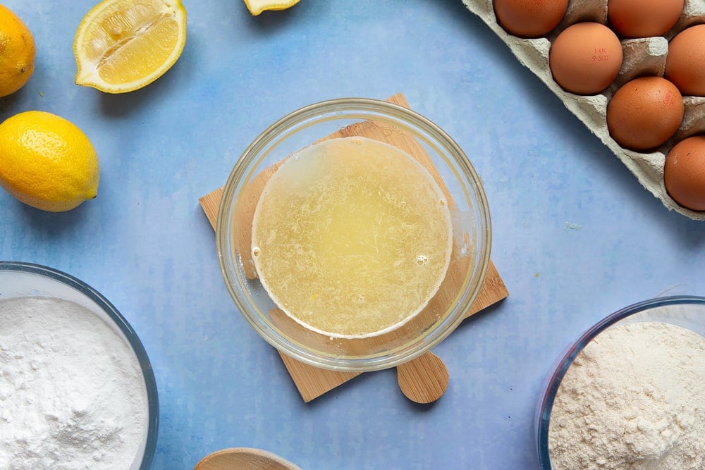 A small glass bowl containing lemon juice and icing sugar mixed together.