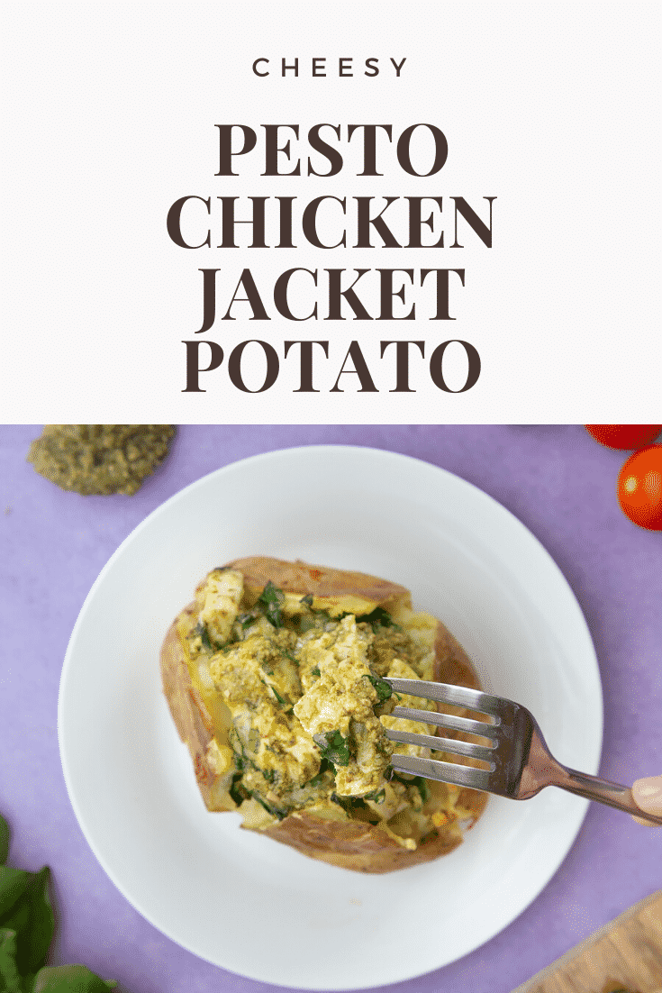 A jacket potato with cheesy pesto chicken on a white plate. A fork delves in. Caption reads: cheesy pesto chicken jacket potato