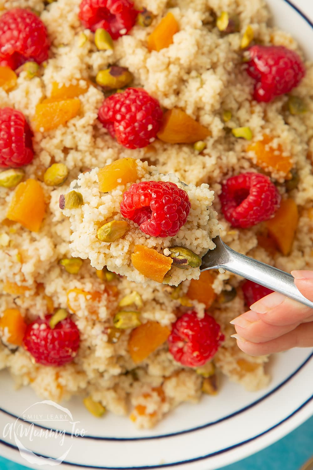 Close up shot of a spoon going into the bowl of sweet breakfast couscous