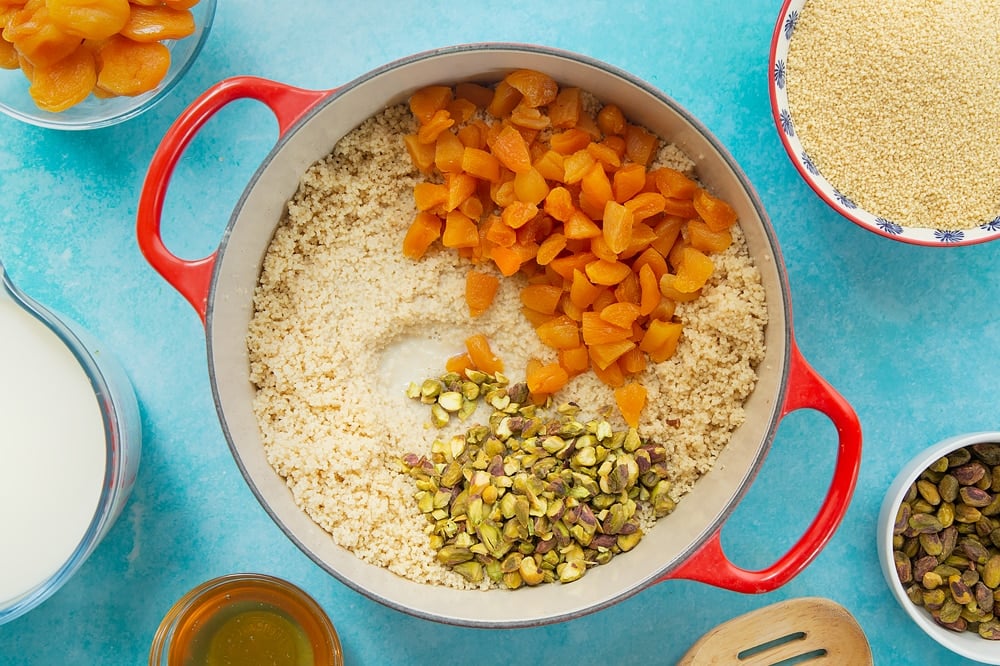 Adding the remaining ingredients to the pan of sweet breakfast couscous. 