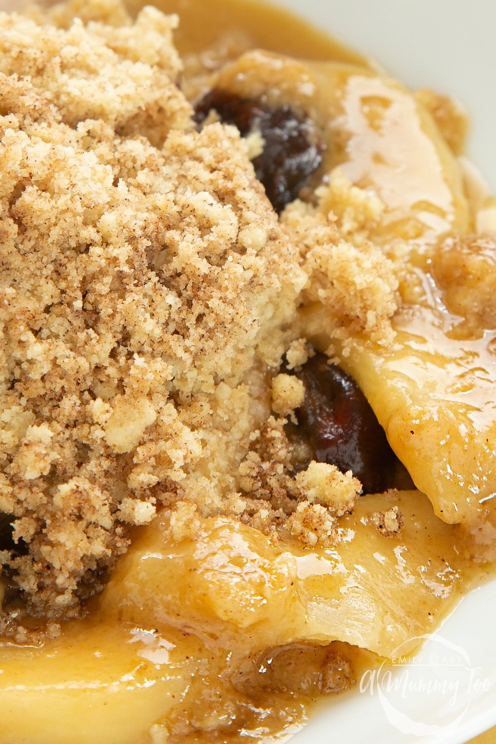 Close up shot of Toffee apple crumble on a white plate. 