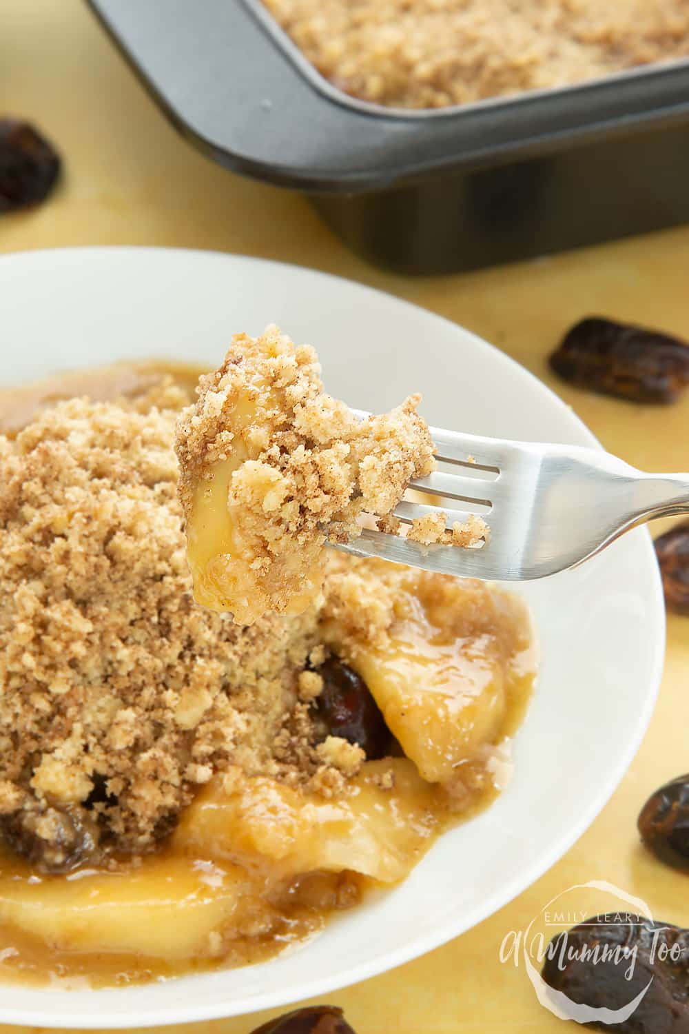 Fork with toffee apple crumble taken from the plate. 