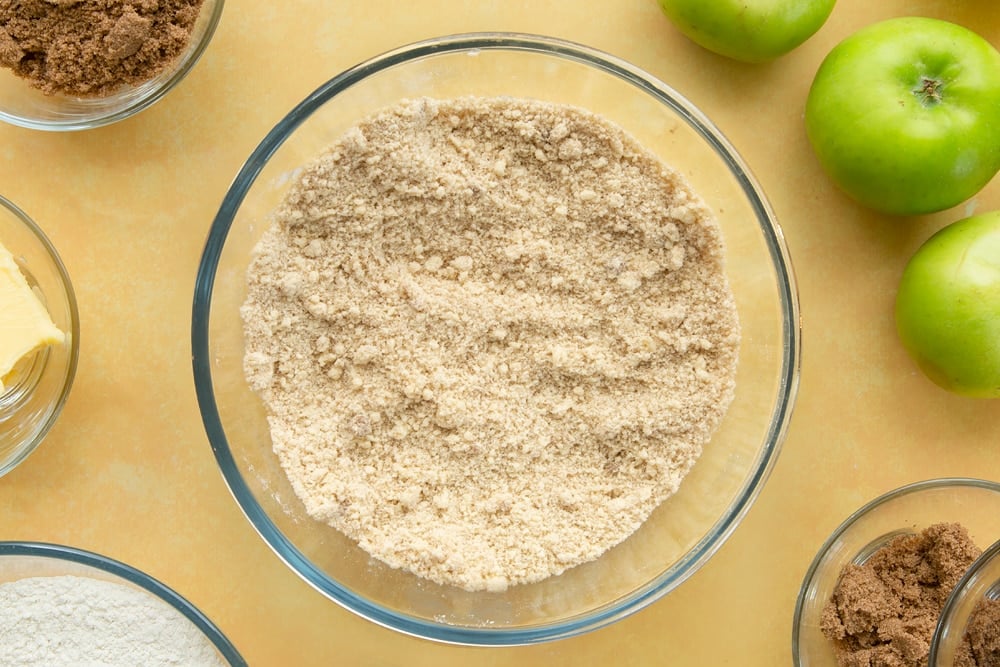 Overhead shot of a bowl filled with ingredients to make the topping for the toffee apple crumble. 