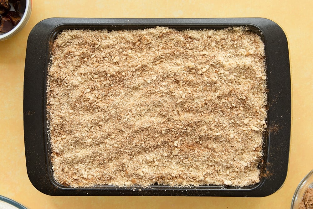 Sprinkling the topping over the apples.