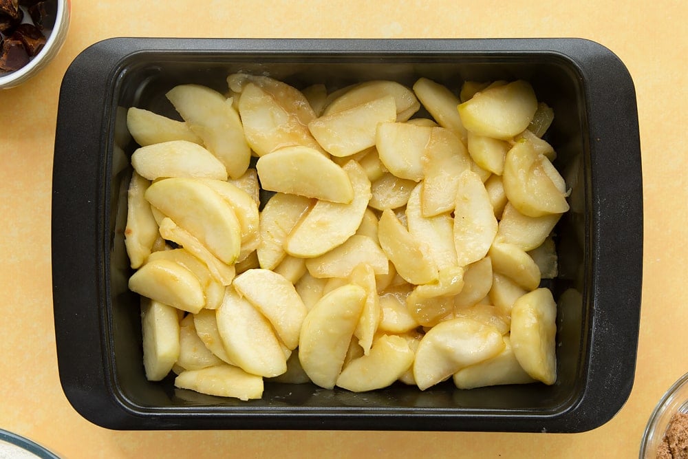 Overhead shot of a greeced oven dish filled with the apples. 