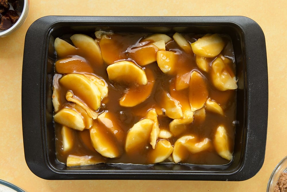 Overhead shot of the toffee being poured over the top of the apples. 