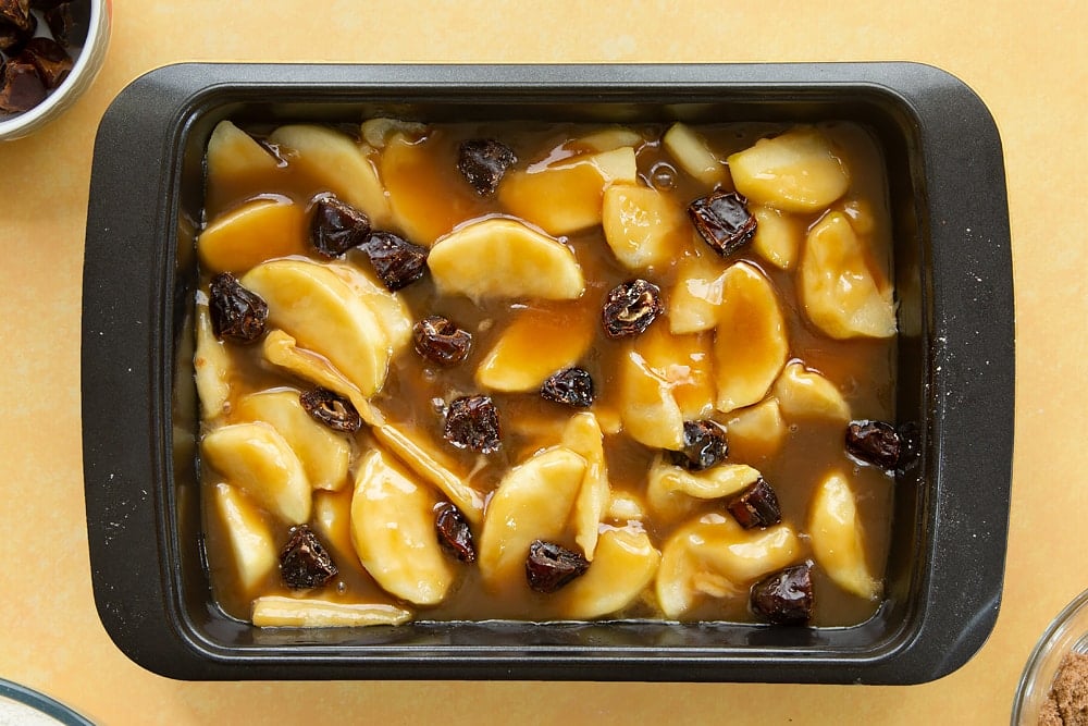 Adding dates to the toffee and apple mixture inside the pan. 