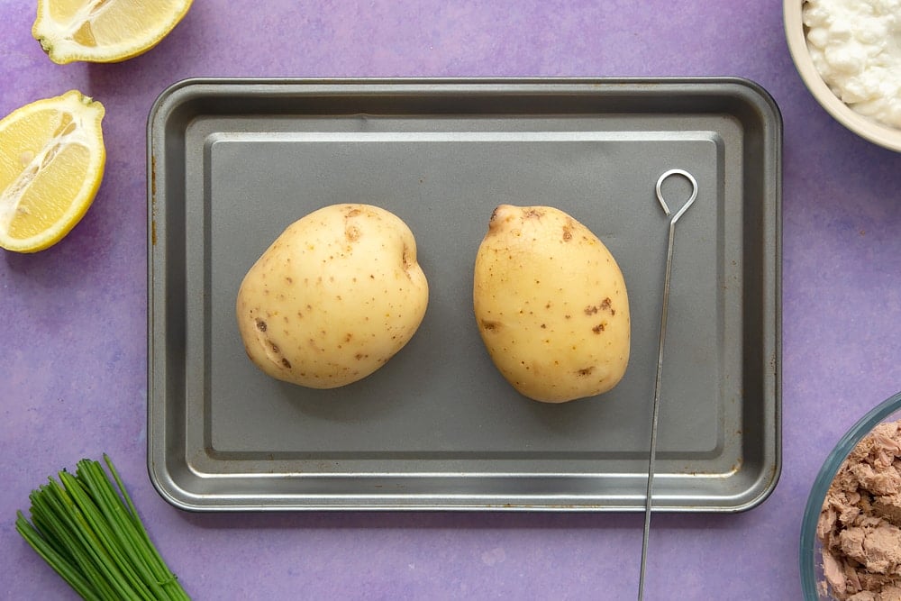 To begin making the low-fat tuna cheese jacket potato we skewer the potatoes. 