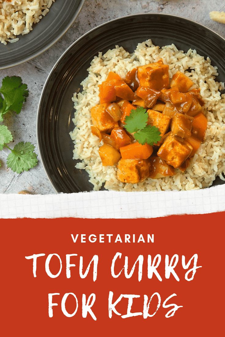 Overhead shot of tofu curry on a black plate with some white text describing the image for Pinterest.