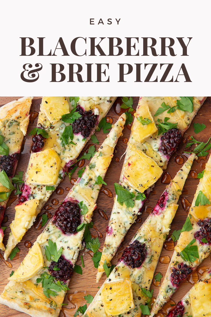 Brie and blackberry pizza sliced on a wooden board and scattered with fresh parsley and drizzled with honey. Caption reads: Easy brie & blackberry pizza.