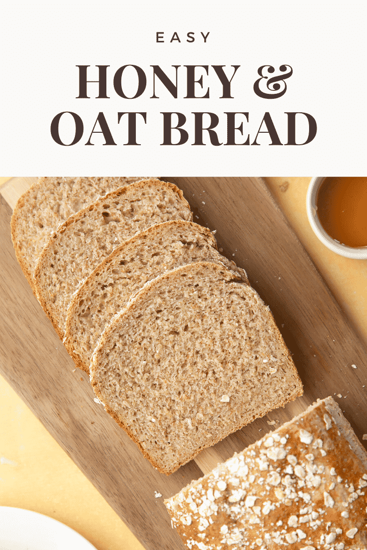 Sliced easy honey and oat bread on a wooden chopping board. At the top of the image there's some text describing the image for Pinterest.