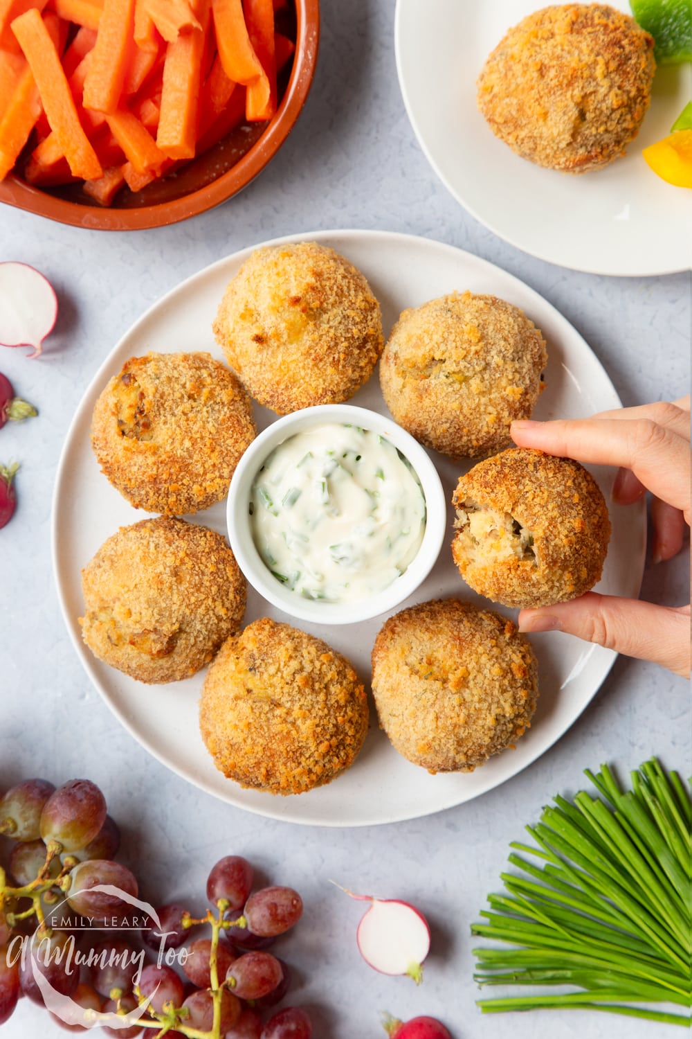 A peak inside one of the smoked mackerel fishcakes on a plate with a crème fraîche and chives dip.