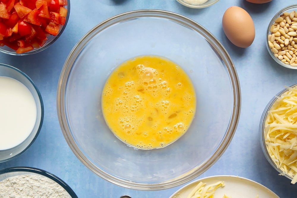 A beaten egg in a bowl ready to make the cheese and red pepper muffins.