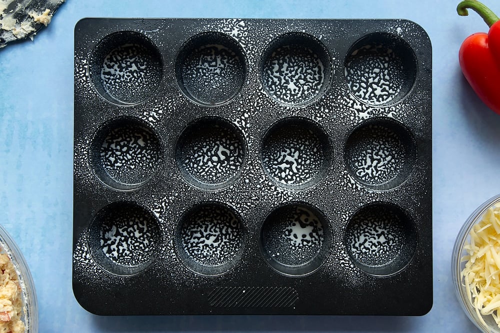 A sprayed non-stick muffin tray with cooking oil. 