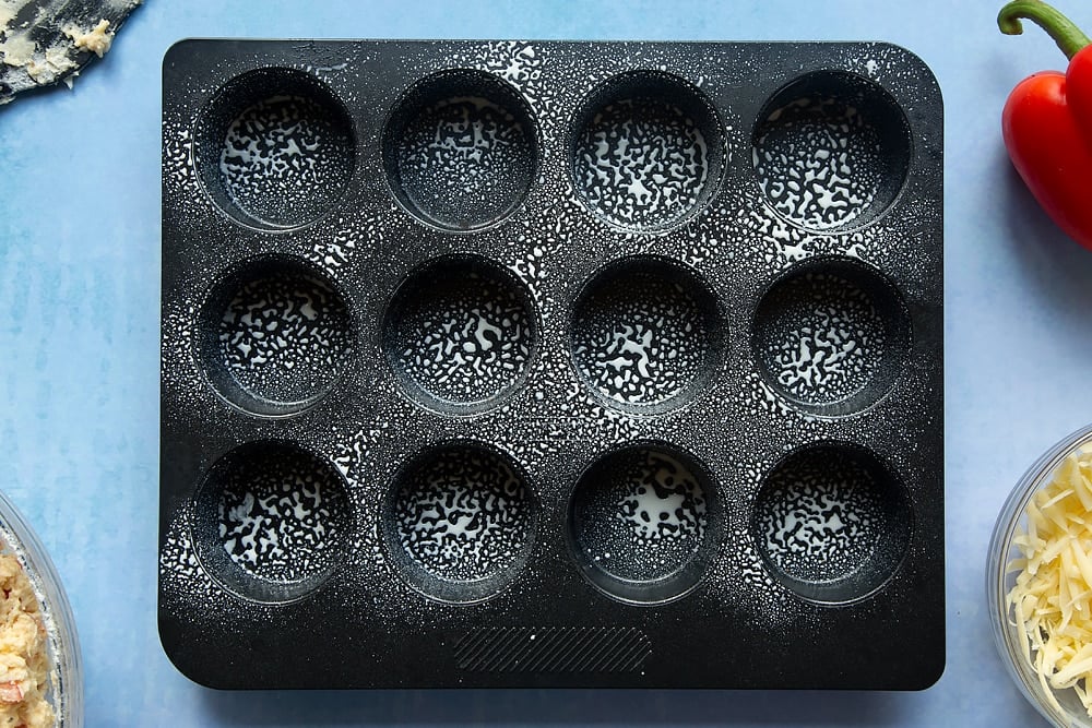 A sprayed non-stick muffin tray with cooking oil.