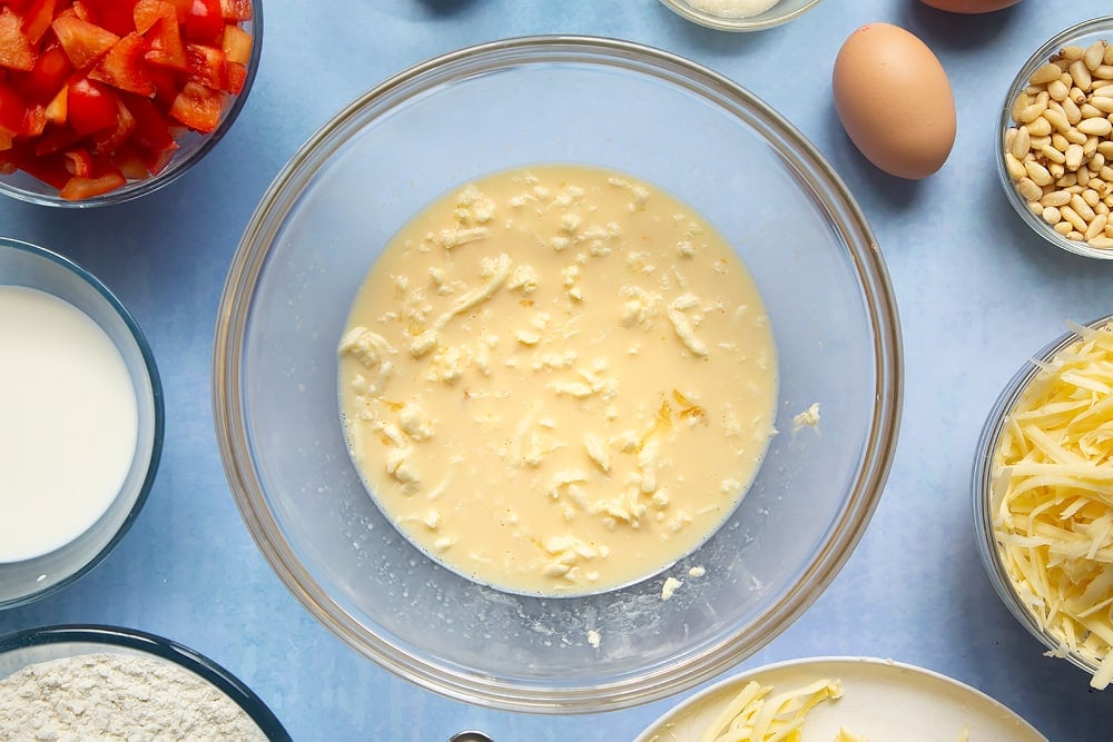 Mixing together some of the ingredients into a bowl for the cheese and red pepper muffins.