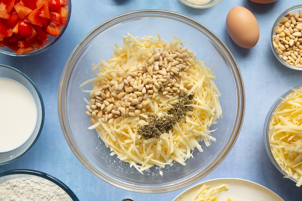 Adding nuts and spice mix into the bowl of cheese and red pepper muffin ingredients.