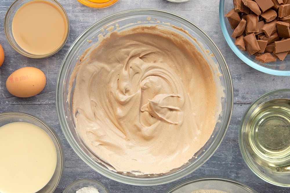 Whisked Baileys and cream in a serving bowl for the galaxy chocolate cake