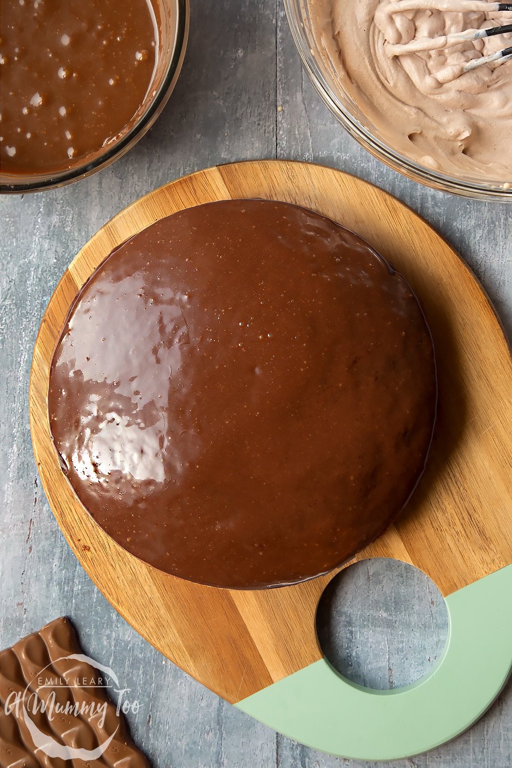 Adding the ganache to the top of the two layers of galaxy chocolate cake