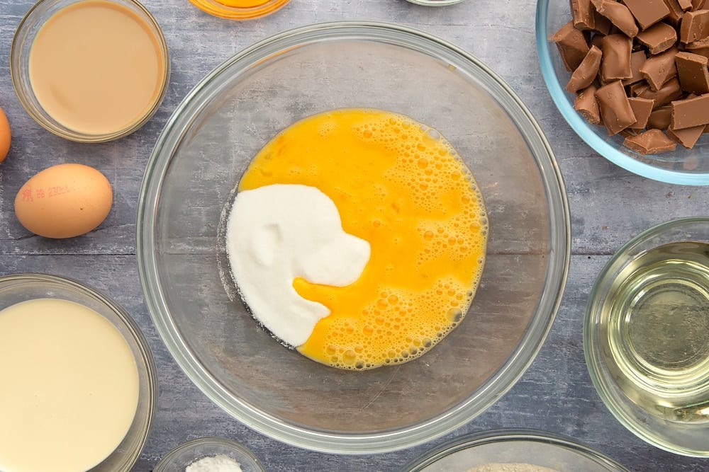 Starting the galaxy chocolate cake ingredients with sugar and beaten eggs in a mixing bowl.