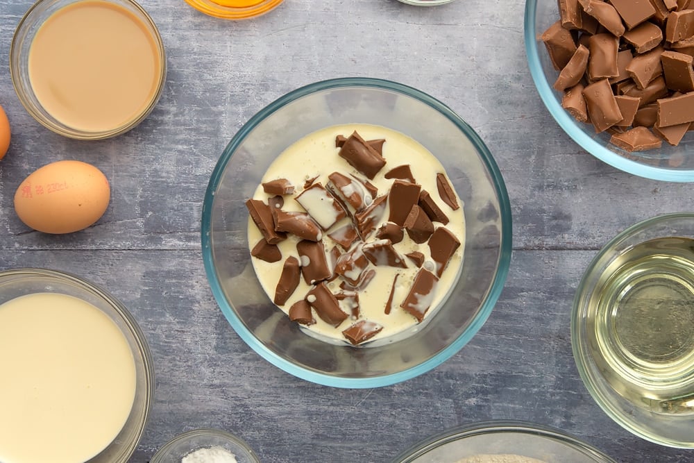 Adding cream to the chocolate to make the galaxy chocolate cake ganche. 